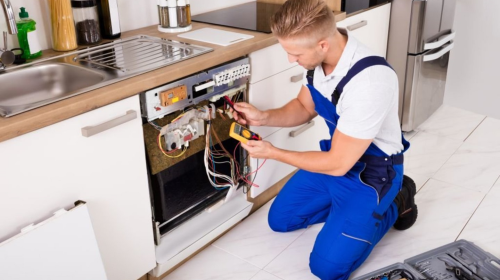 Certified technician providing residential appliance repair services in Pennsville Township, NJ, fixing a appliance in a home setting.